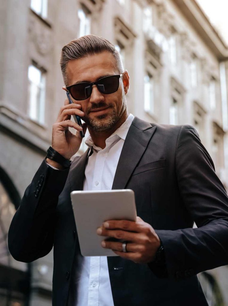 Image of a businessman working remotely and talking on the phone.