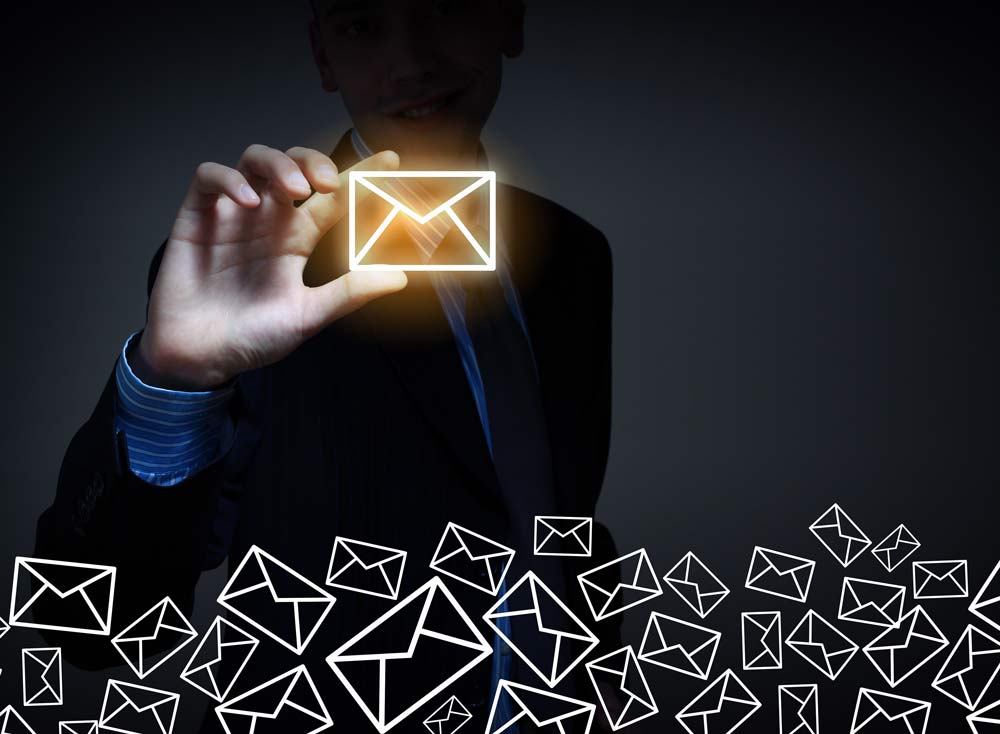 Image of a businessman holding up a glowing envelope.