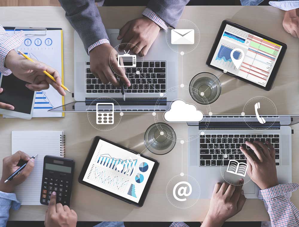 Image of a group of professionals working on devices at a conference table.