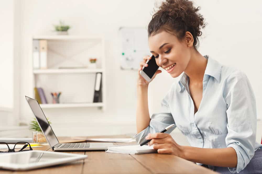 Image of a business woman talking on the phone at her desk